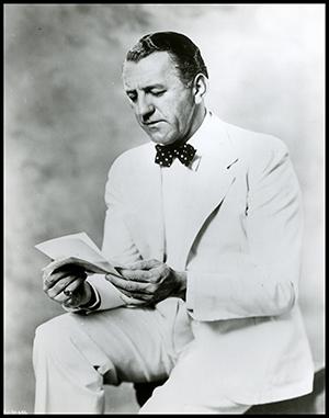 man in white suit reading a letter